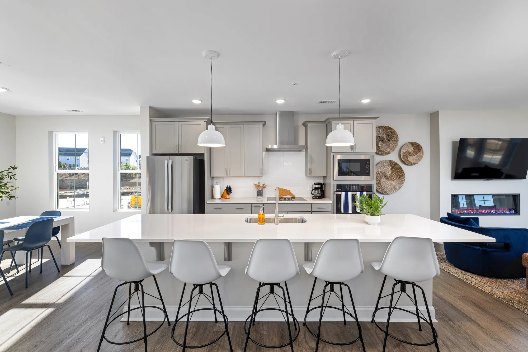 Kitchen island with white chairs and the dining and living area visible past it