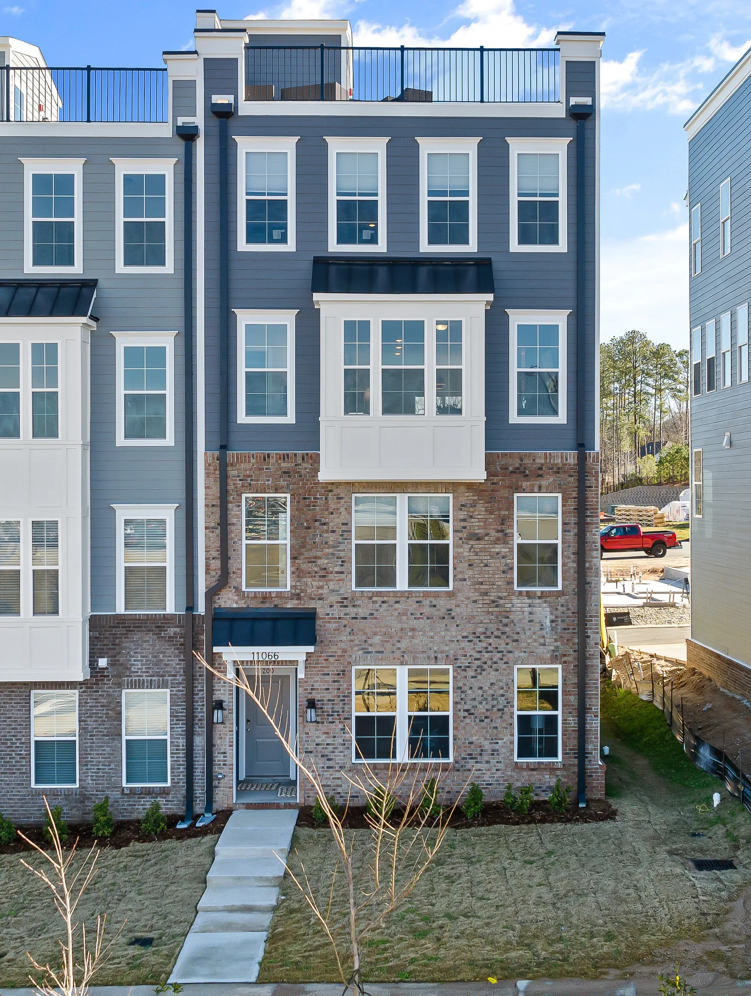 Portrait crop of the townhome front elevation with the roof deck rail at the top