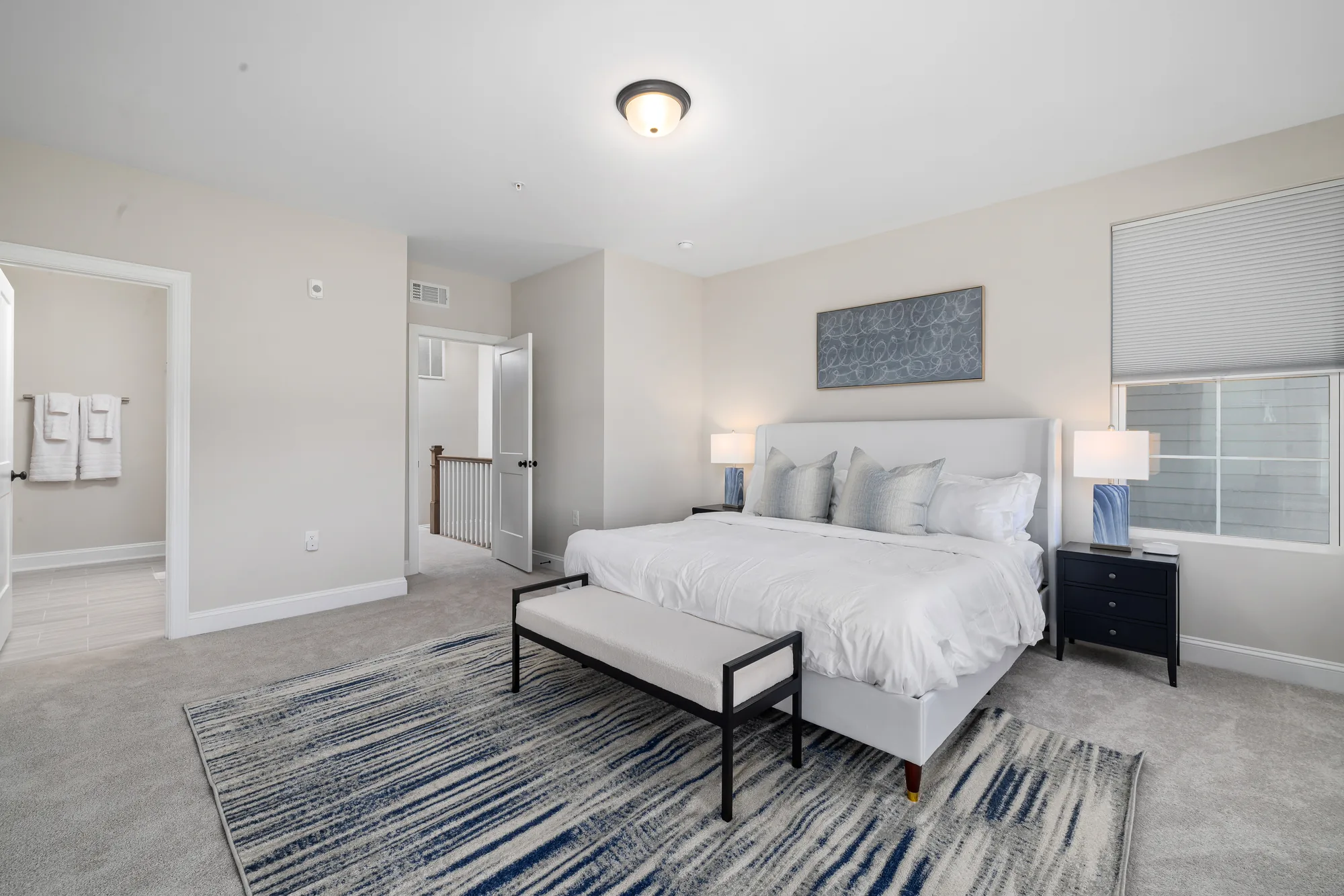 White bed with the doorway through to the bathroom visible on the far wall
